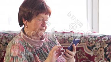 一位老年妇女在手机上写短信。 她小心翼翼地按在屏幕上，发短信。